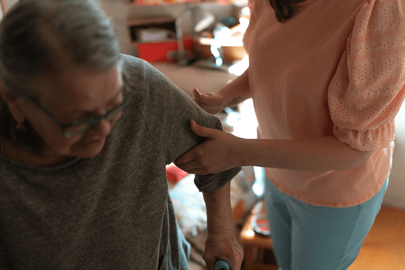 Caregiver helping elderly woman at home | Senior caregiver burnout | Neighborly Home Care